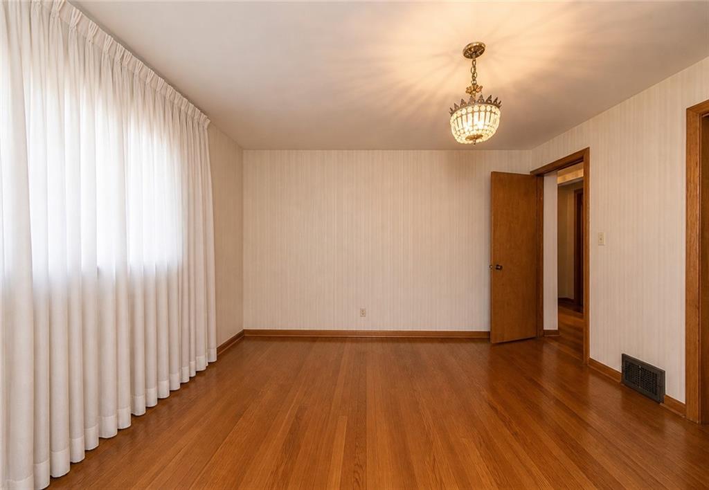 719 Locust Street Greensburg, PA 15601 - Photo 5 of 18 an empty room with wooden floor and windows