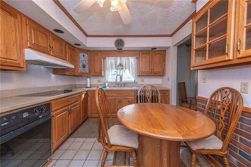 719 Locust Street Greensburg, PA 15601 - Photo 7 of 18 a kitchen with stainless steel appliances granite countertop a sink a stove a kitchen island with chairs and wooden floor