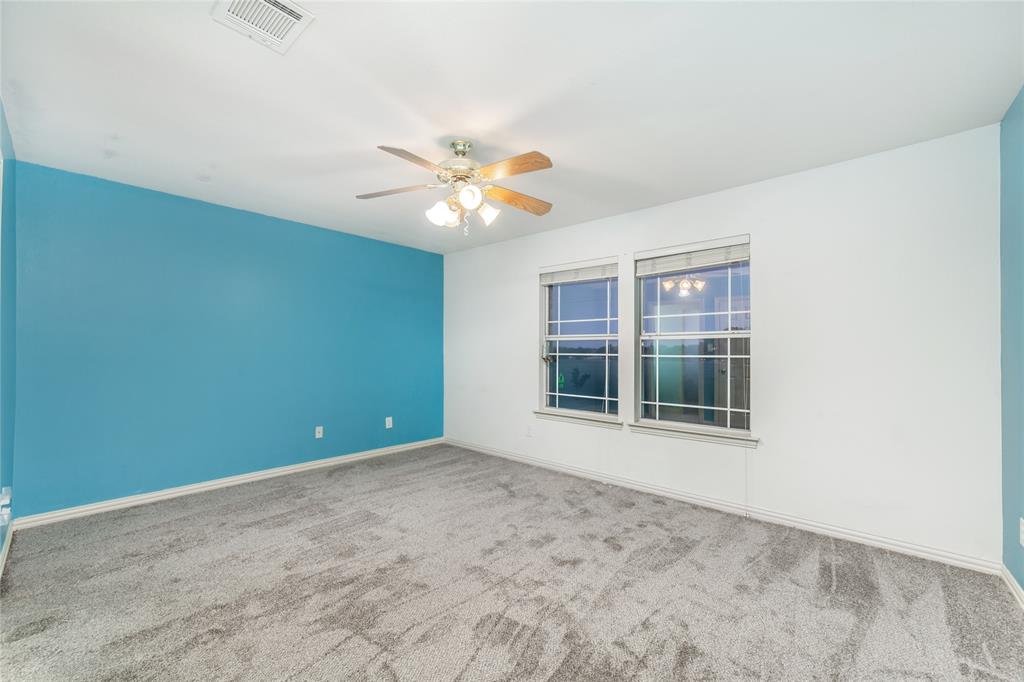5801 Yeary Road Plano, TX 75093 - Photo 31 of 33 Spacious room featuring a blue accent wall, white walls, and gray carpet flooring