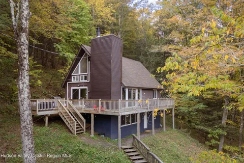 a view of a house with a yard and deck