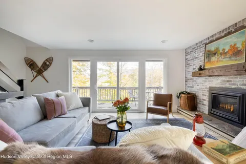 a living room with furniture a fireplace and a large window