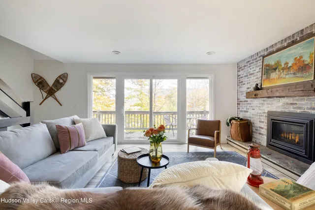 a living room with furniture a fireplace and a large window