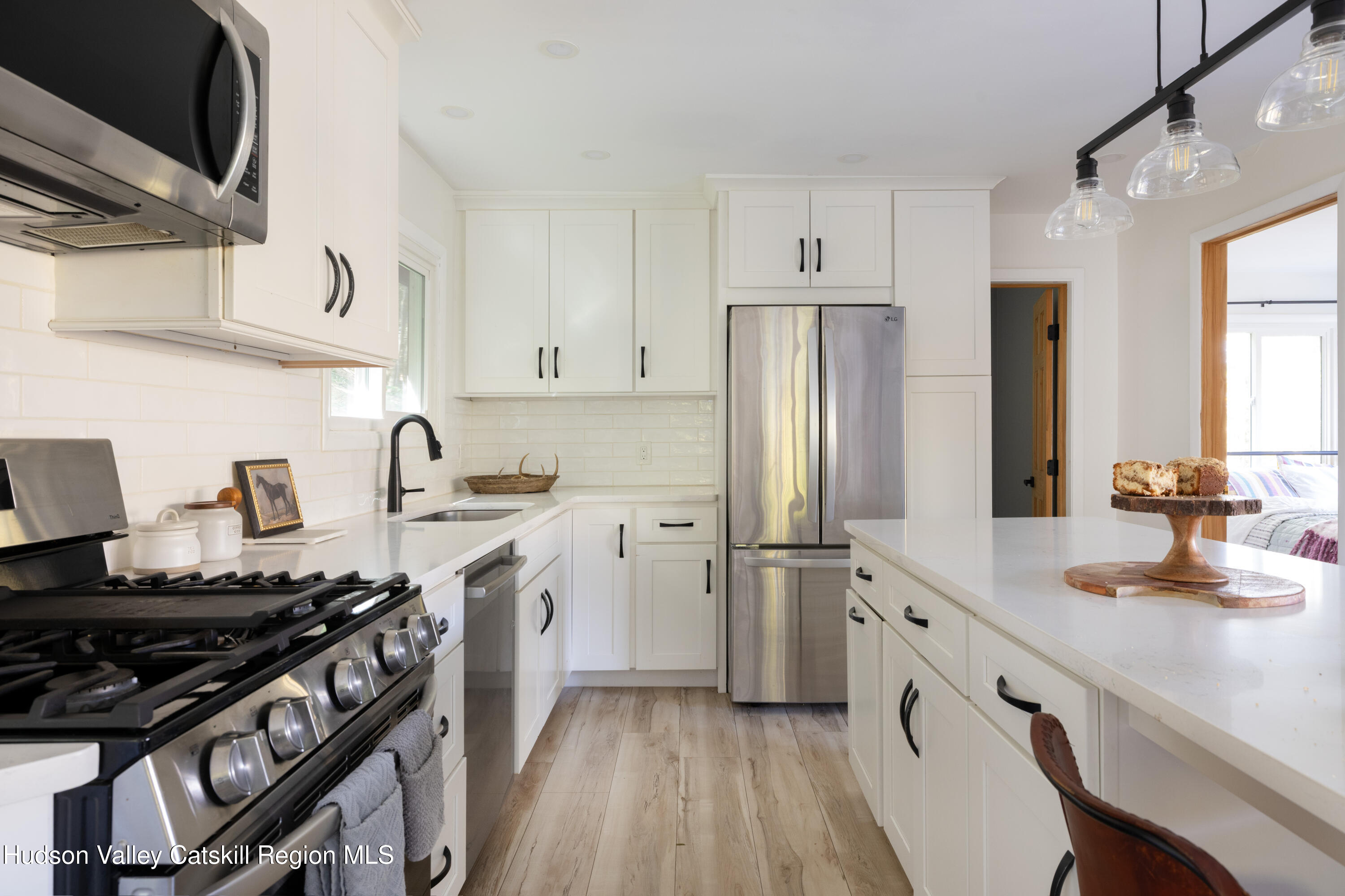 6 Clearview Road Hunter, NY 12442 - Photo 21 of 31 a kitchen with stainless steel appliances a stove a sink dishwasher a refrigerator white cabinets and wooden floor