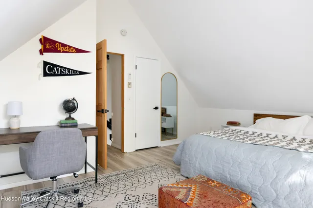 a bedroom with a bed and a wooden floor