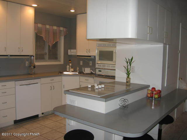 726 Decker Road Bushkill, PA 18324 - Photo 2 of 28 a kitchen with granite countertop a sink white cabinets and stove