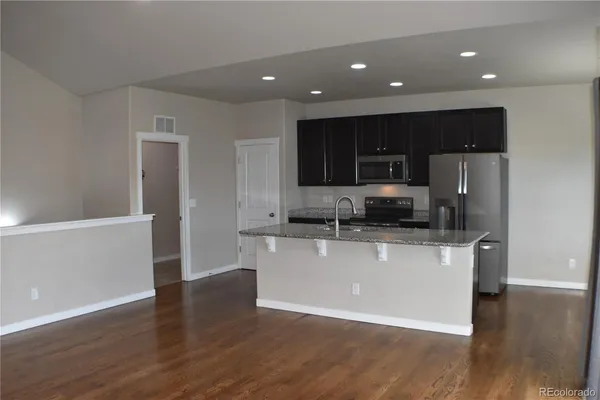 a kitchen with stainless steel appliances a refrigerator and a stove top oven