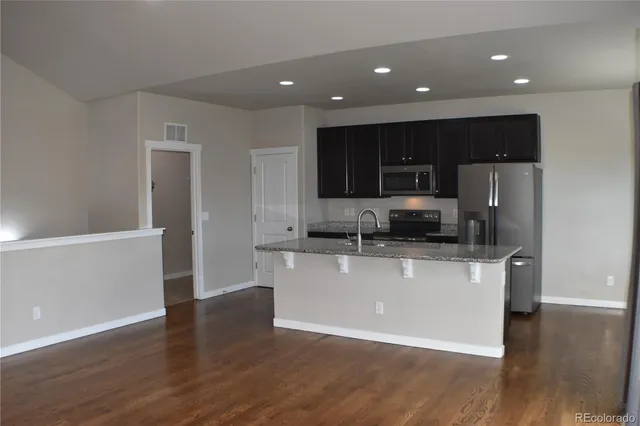a kitchen with stainless steel appliances a refrigerator and a stove top oven