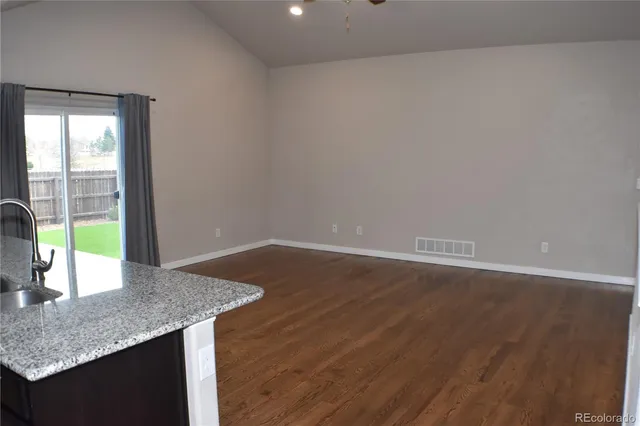 a kitchen with granite countertop a sink and a wooden floor