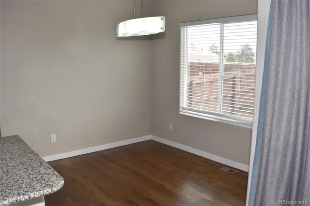 a view of a room with wooden floor and a window