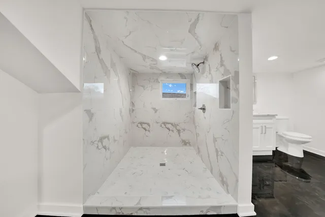 a bathroom with a sink a toilet and shower