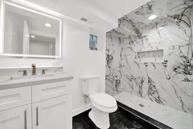 a bathroom with a sink a toilet and shower