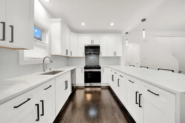 a large kitchen with a white stove top oven and sink