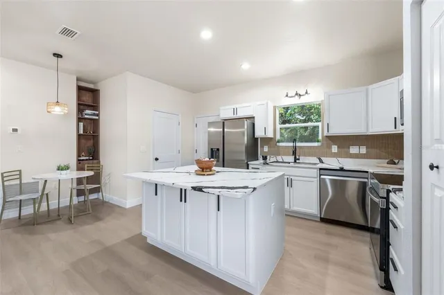 a kitchen with appliances a sink a counter top space and cabinets