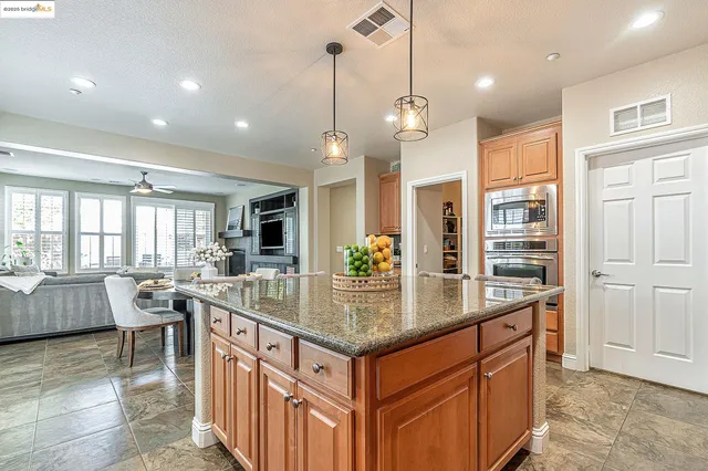a large kitchen with kitchen island lots of counter space windows and a chandelier