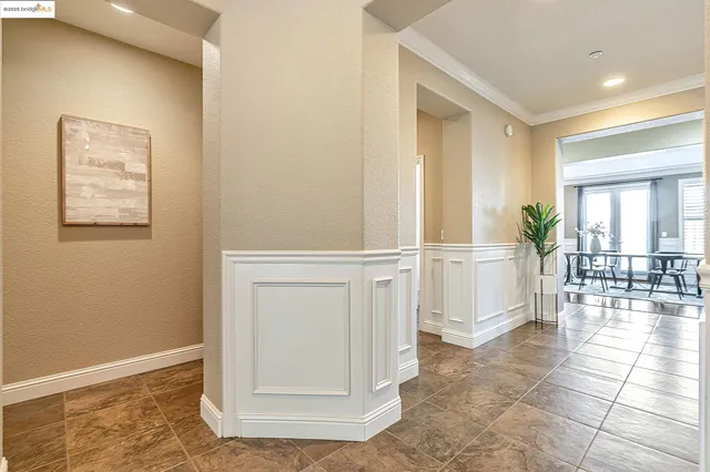 a spacious bedroom with a bed a mirror and a lamp on dresser
