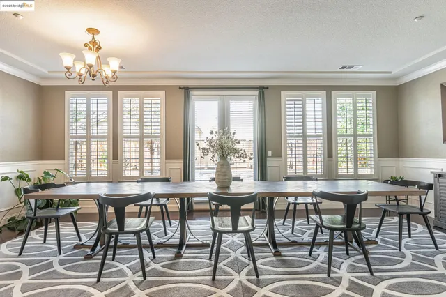 a kitchen with a dining table chairs stainless steel appliances and cabinets