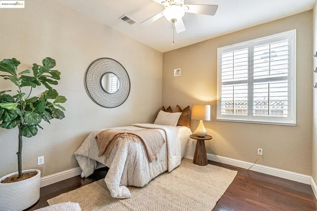 a bedroom with a bed and a lamp on dresser