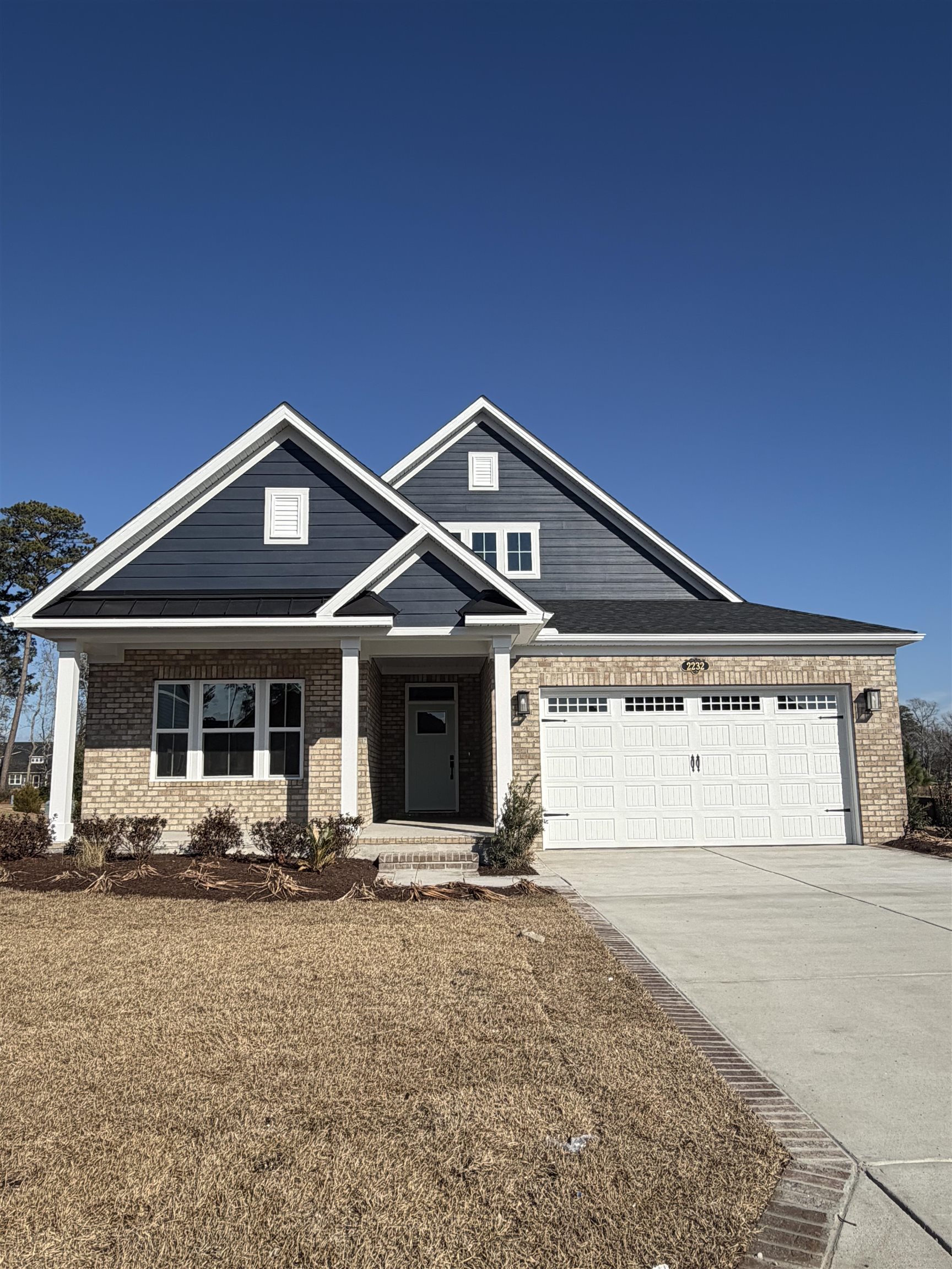 2232 Hazel Way Longs, SC 29568 - Photo 1 of 2 View of front of home with covered porch, brick siding, concrete driveway, and a garage