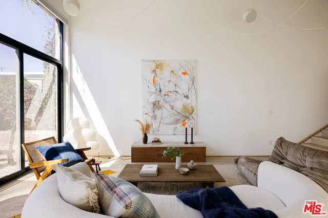 a living room with furniture and floor to ceiling windows