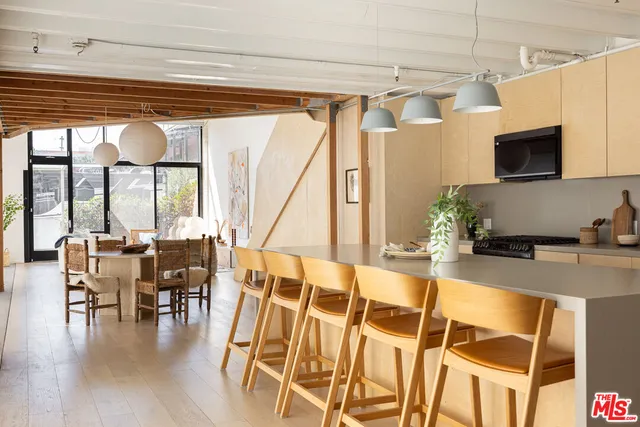 a dining room with wooden floor table and chairs
