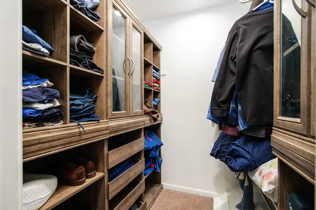 a view of walk in closet with clothes and shoes