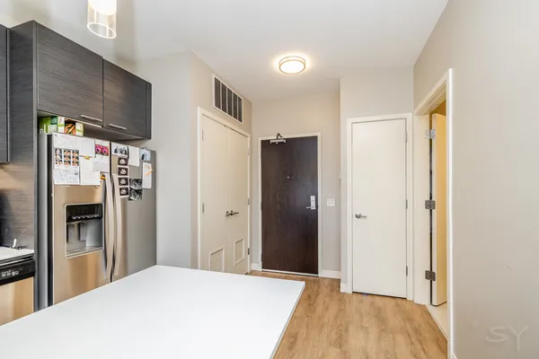a view of a kitchen with refrigerator and windows