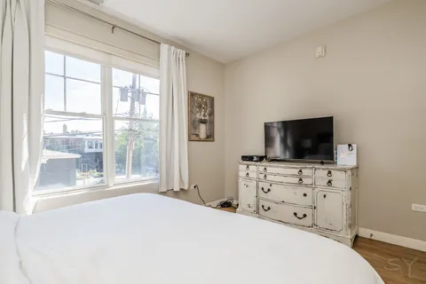 a bedroom with a bed and a flat screen tv