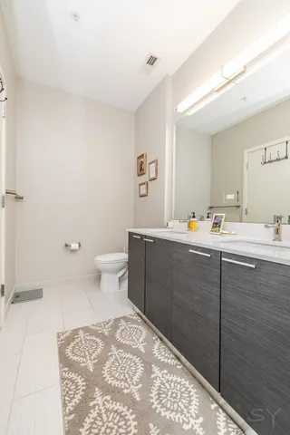 a bathroom with a sink vanity mirror and toilet