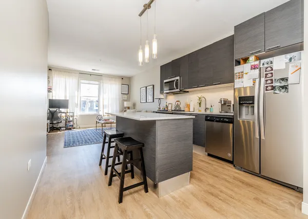 a kitchen with stainless steel appliances kitchen island granite countertop a refrigerator and a stove top oven