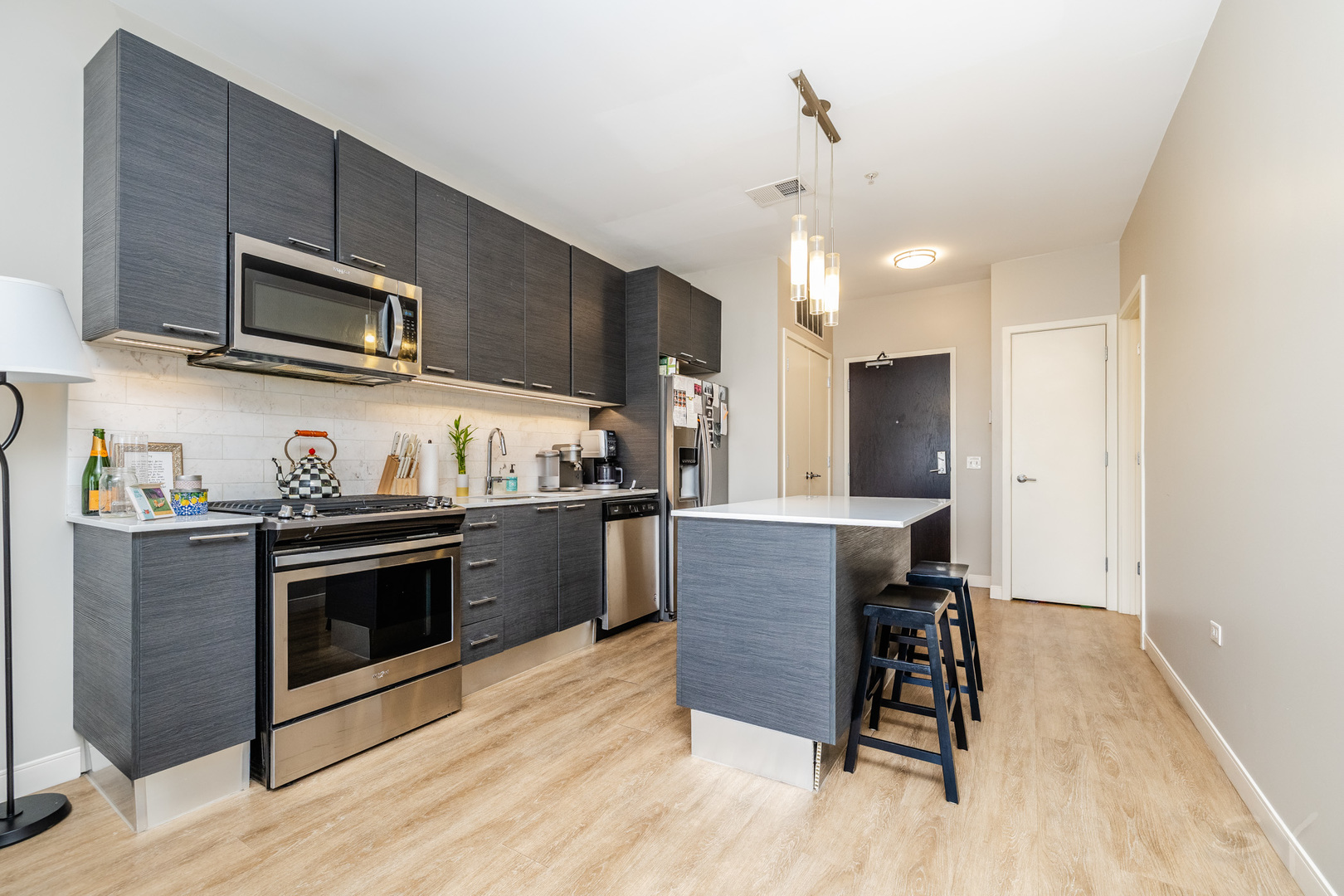 229 Park Avenue, Unit 202 Clarendon Hills, IL 60514 - Photo 10 of 22 a kitchen with stainless steel appliances granite countertop a stove top oven a sink dishwasher a dining table and chairs with wooden floor