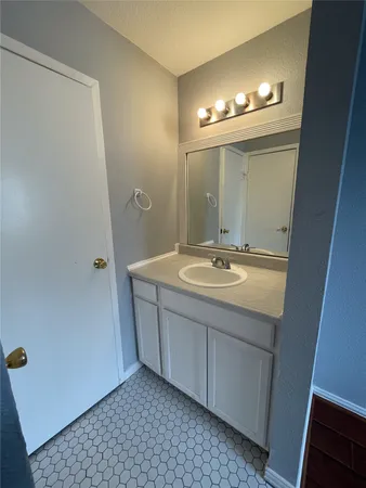 a bathroom with a sink a light fixture and a mirror