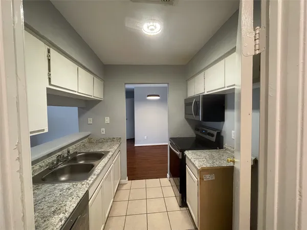 a kitchen with granite countertop a sink and a stove top oven