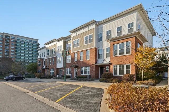 a front view of a building with lot of trees