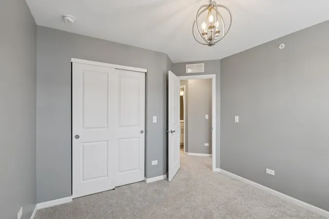 an empty room with wooden floor and a ceiling fan