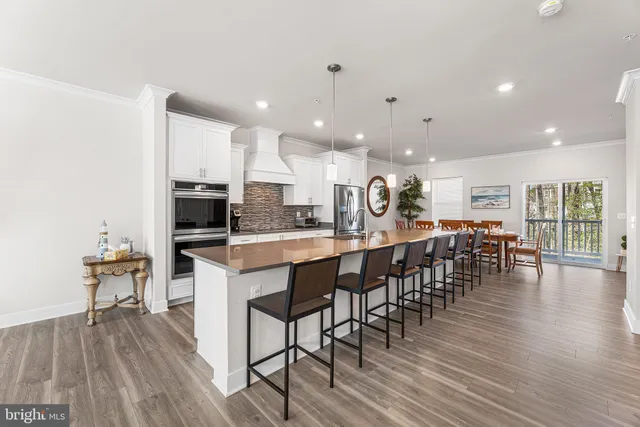 a kitchen with lots of counter space a sink appliances and living room view