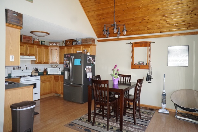 7054 South Rock Nation Road Dixon, IL 61021 - Photo 8 of 17 a kitchen with refrigerator and chairs