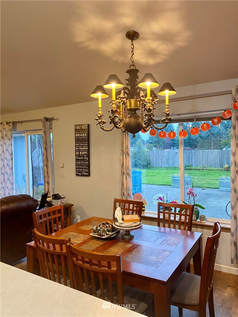 8016 188th Avenue Southwest Rochester, WA 98579 - Photo 7 of 16 a view of a dining room with furniture wooden floor and chandelier