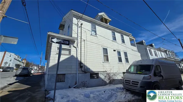 a front view of house with barbeque and wooden fence