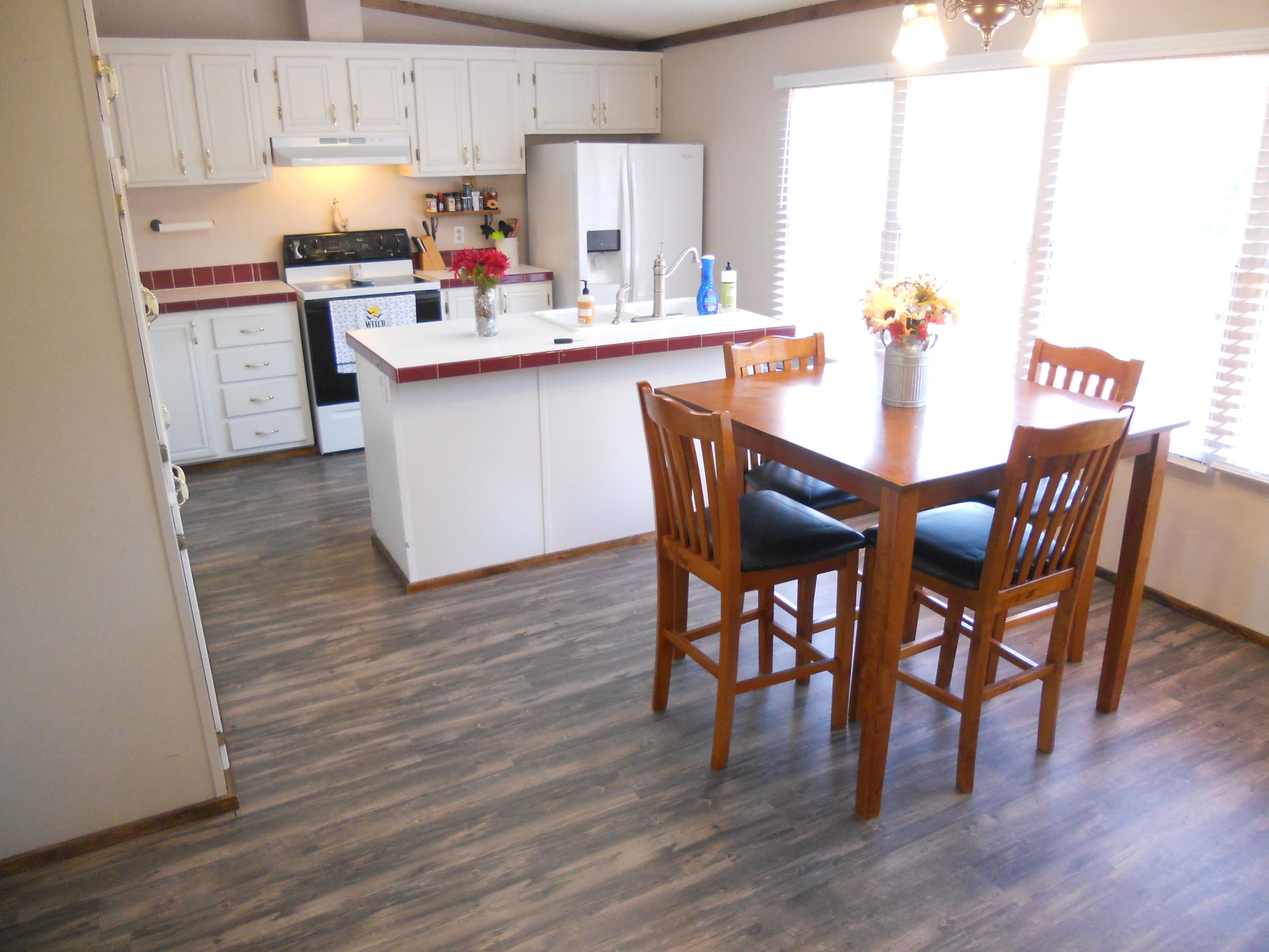 1504 Turner Branch Road Goodview, VA 24095 - Photo 15 of 64 a kitchen with a dining table chairs and white cabinets