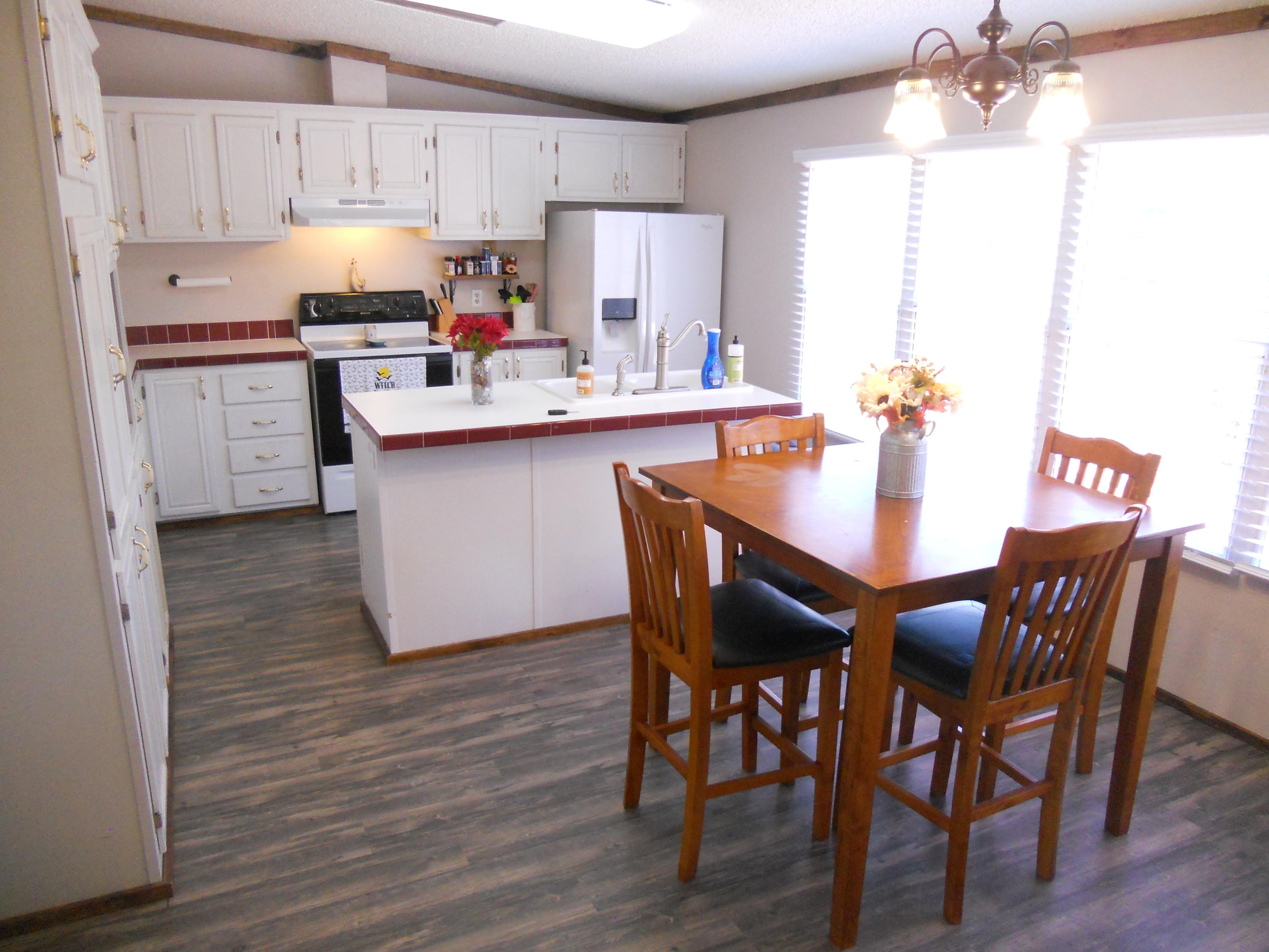 1504 Turner Branch Road Goodview, VA 24095 - Photo 16 of 64 a kitchen with stainless steel appliances granite countertop a white table chairs and a refrigerator