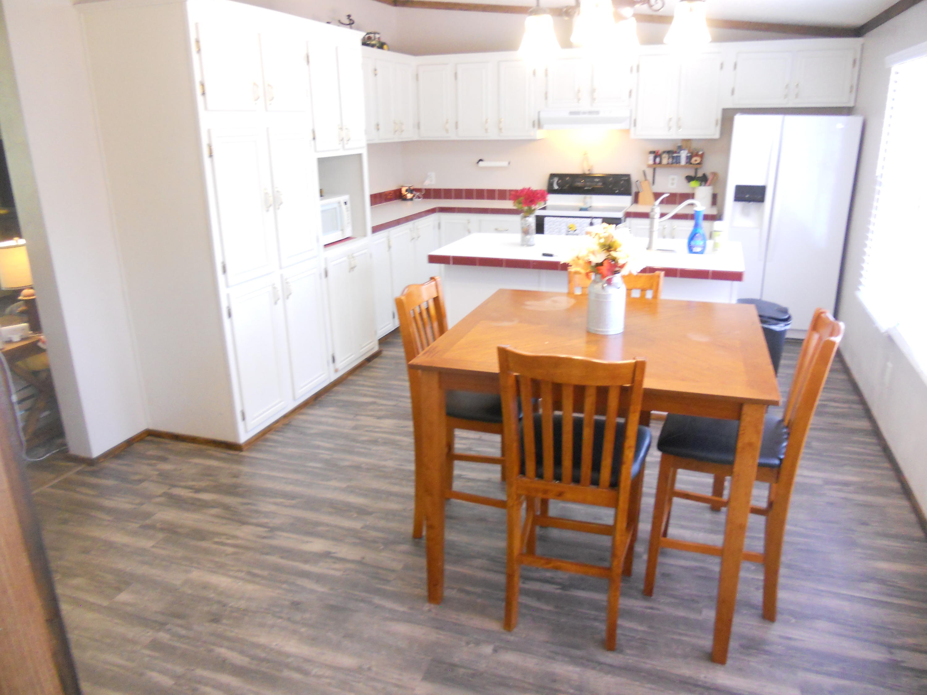 1504 Turner Branch Road Goodview, VA 24095 - Photo 18 of 64 a kitchen with a table chairs and a refrigerator