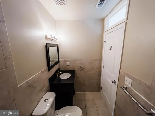 a bathroom with a toilet a sink a mirror and vanity