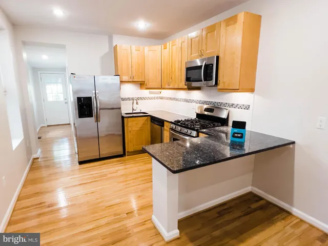 a kitchen with stainless steel appliances granite countertop a sink microwave and cabinets