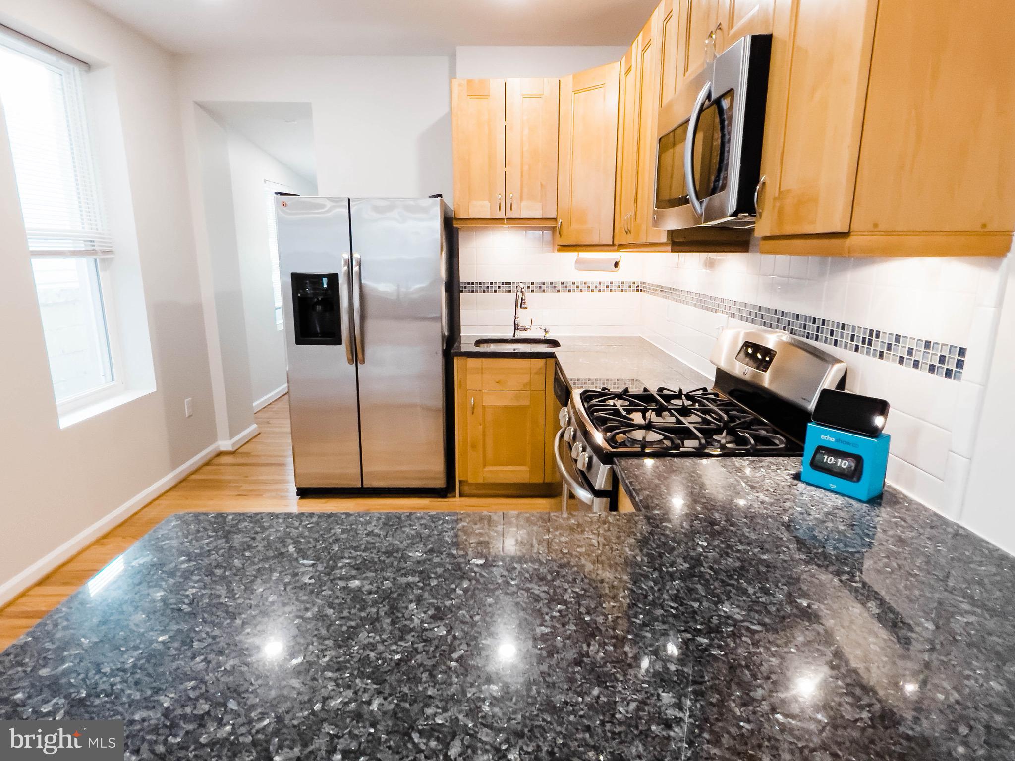 721 South Milton Avenue Baltimore, MD 21224 - Photo 6 of 23 a kitchen with stainless steel appliances granite countertop a sink stove and refrigerator