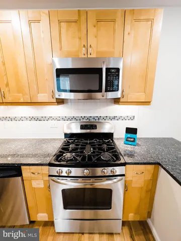 a kitchen with stainless steel appliances granite countertop a stove a microwave and a sink