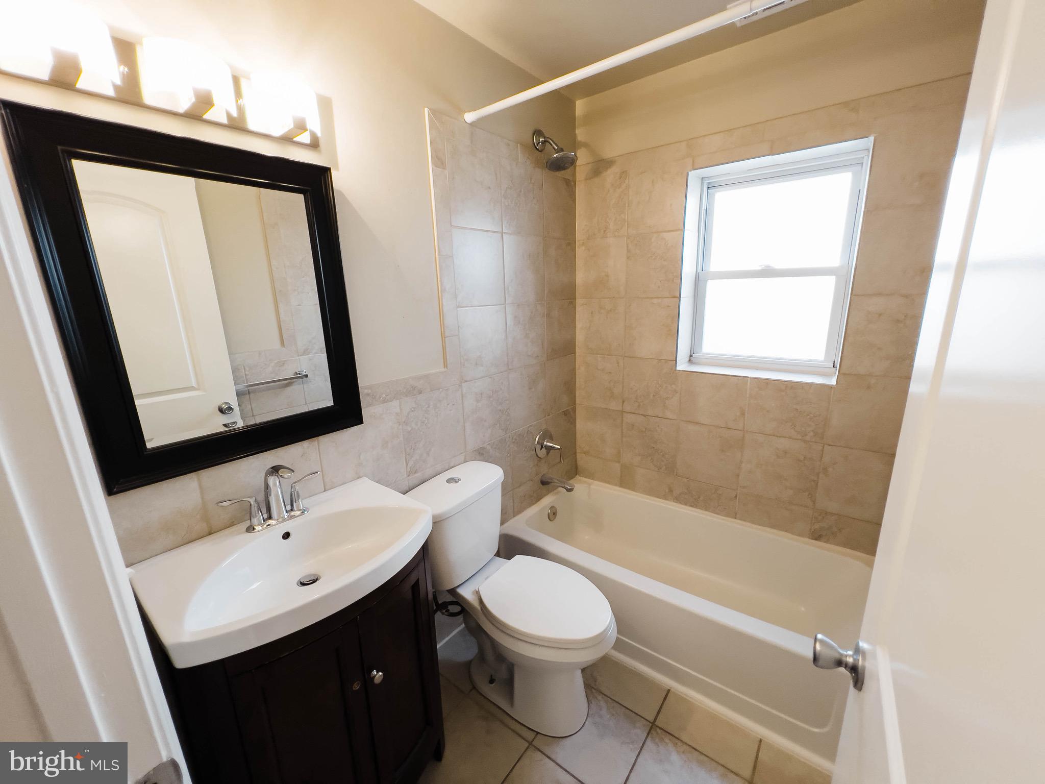 721 South Milton Avenue Baltimore, MD 21224 - Photo 10 of 23 a bathroom with a sink a toilet and shower