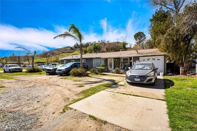 a view of a yard with cars on road