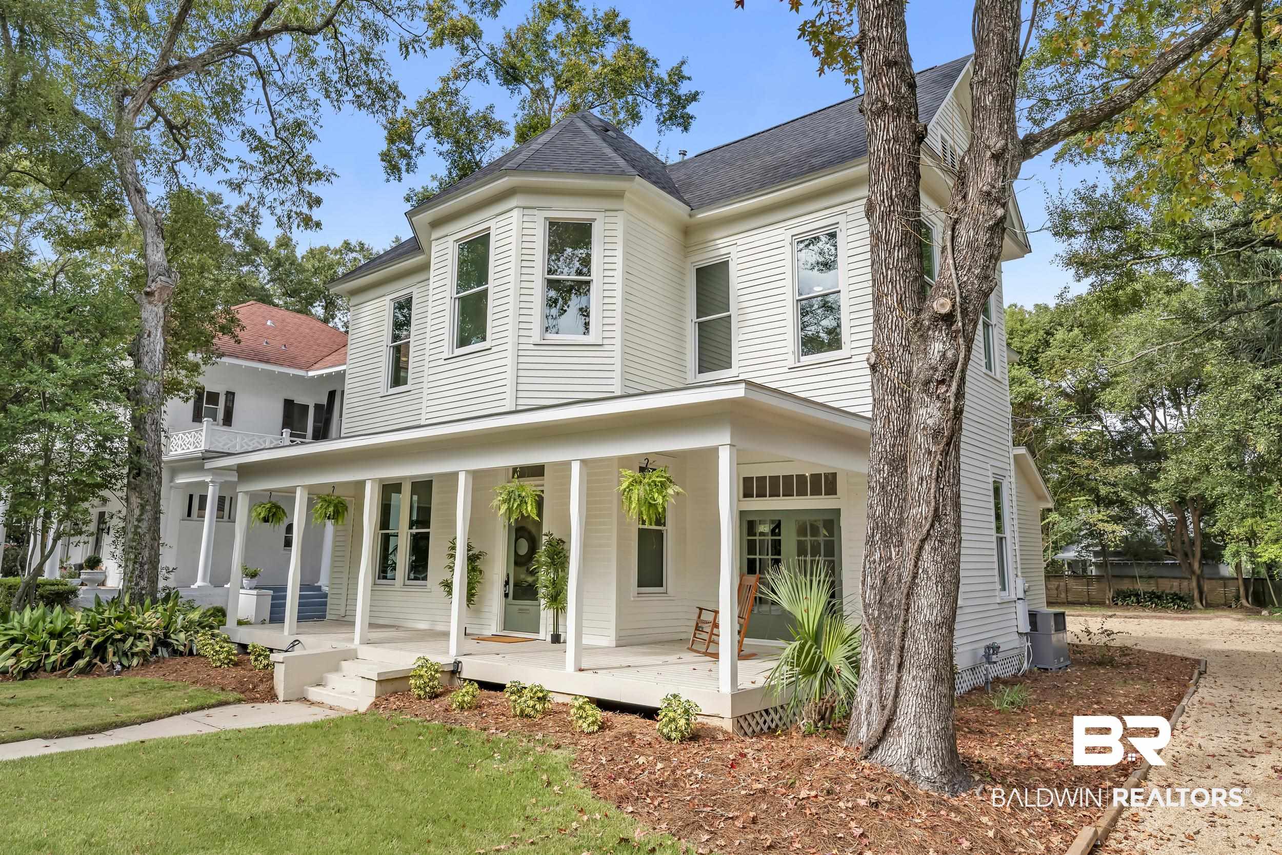 1662 Government Street Mobile, AL 36604 - Photo 3 of 33 Victorian-style house with covered porch, a shingled roof, and a front yard