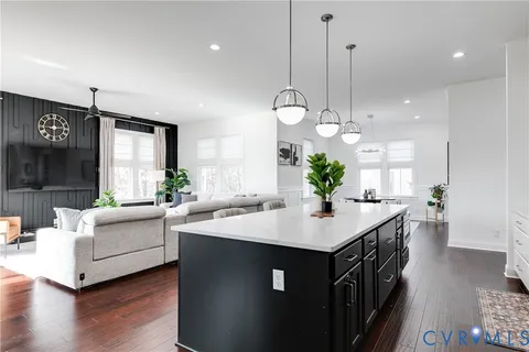 a kitchen with kitchen island granite countertop a sink a counter top space and living room view
