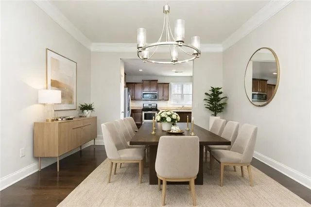 a dining room with wooden floor a chandelier a wooden table and chairs